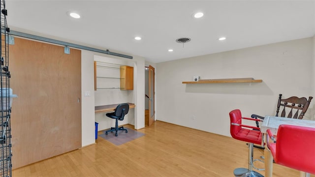 office area featuring hardwood / wood-style floors and built in desk