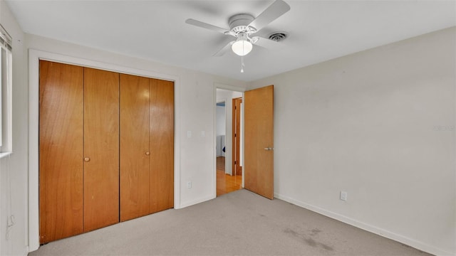 unfurnished bedroom with light colored carpet, a closet, and ceiling fan