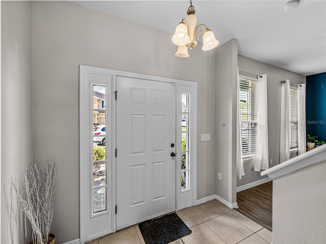 foyer entrance with a notable chandelier and light tile patterned floors