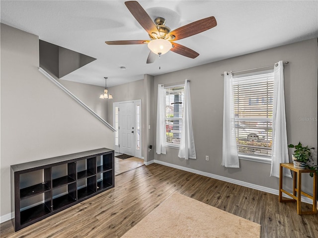 foyer entrance with ceiling fan with notable chandelier and hardwood / wood-style flooring