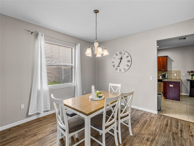 dining area with an inviting chandelier and hardwood / wood-style floors