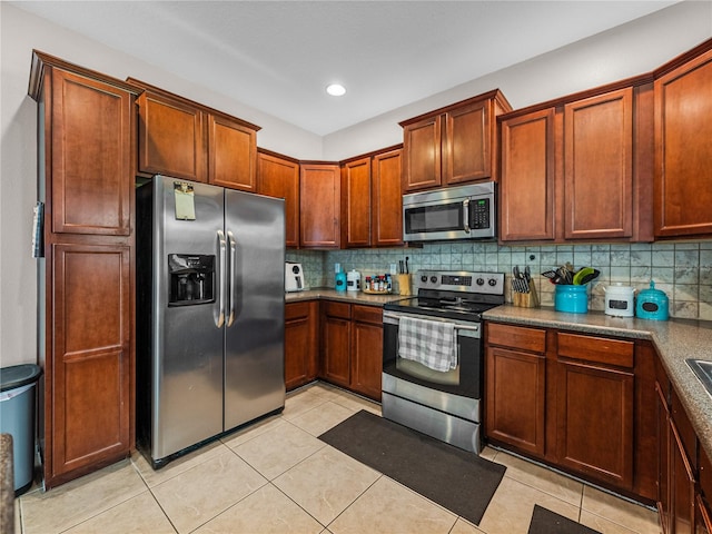 kitchen featuring appliances with stainless steel finishes, light tile patterned floors, and backsplash