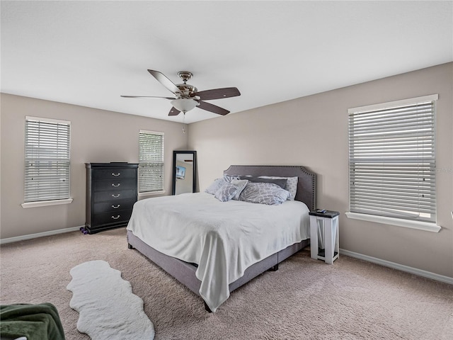 carpeted bedroom featuring multiple windows and ceiling fan