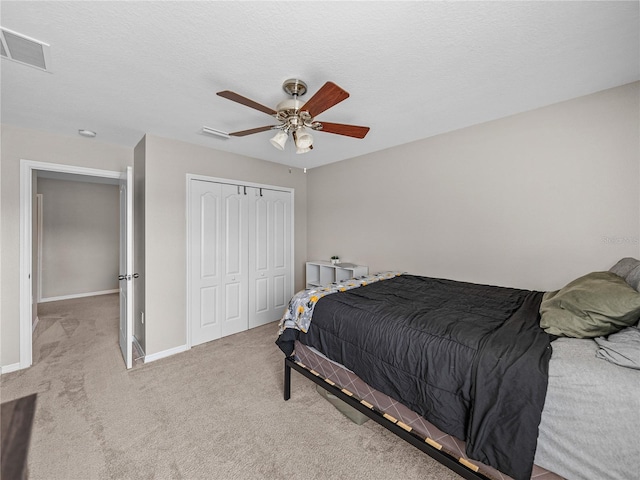 carpeted bedroom with ceiling fan and a closet