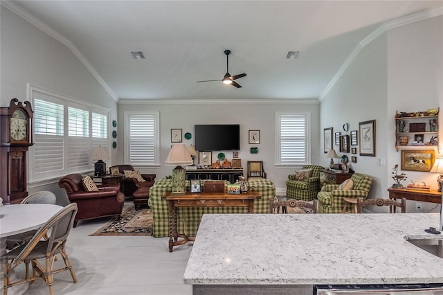 living room with ornamental molding, lofted ceiling, plenty of natural light, and ceiling fan