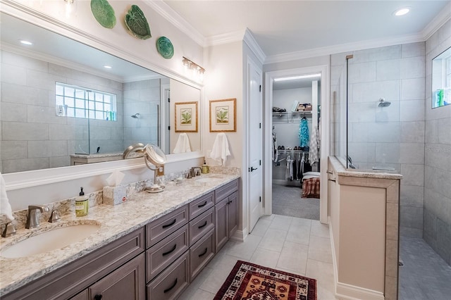 bathroom featuring vanity, tile patterned flooring, ornamental molding, and tiled shower