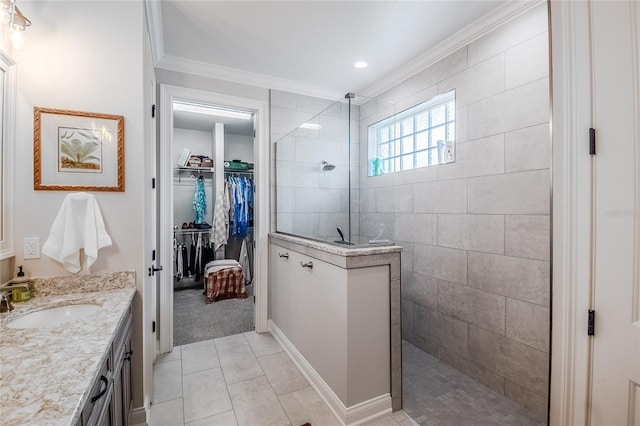 bathroom with vanity, a tile shower, tile patterned floors, and crown molding