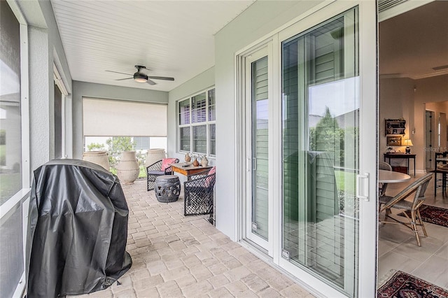 sunroom / solarium featuring ceiling fan