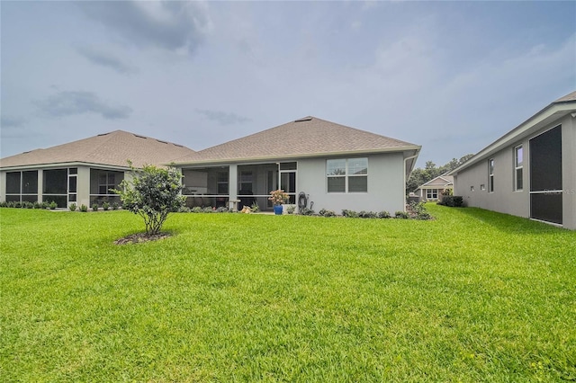 back of house with a sunroom and a lawn