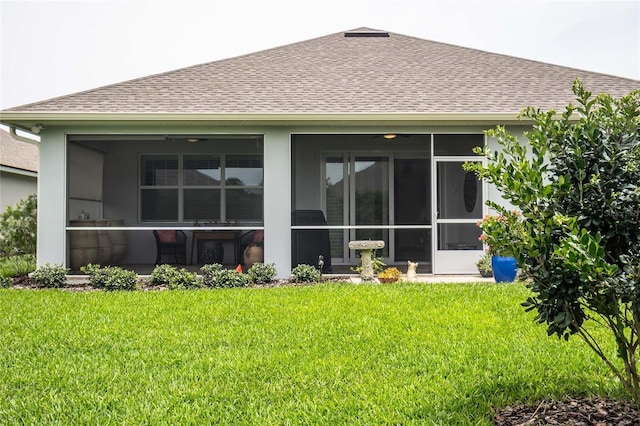 rear view of house with a sunroom and a lawn