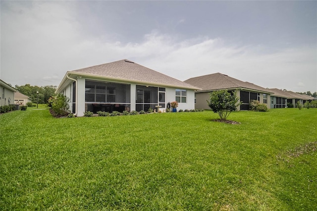 rear view of house with a sunroom and a lawn