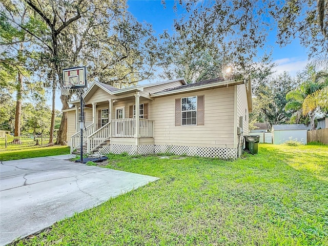 view of front of property with a porch, a storage unit, and a front lawn