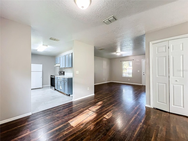 unfurnished living room with a textured ceiling and wood-type flooring