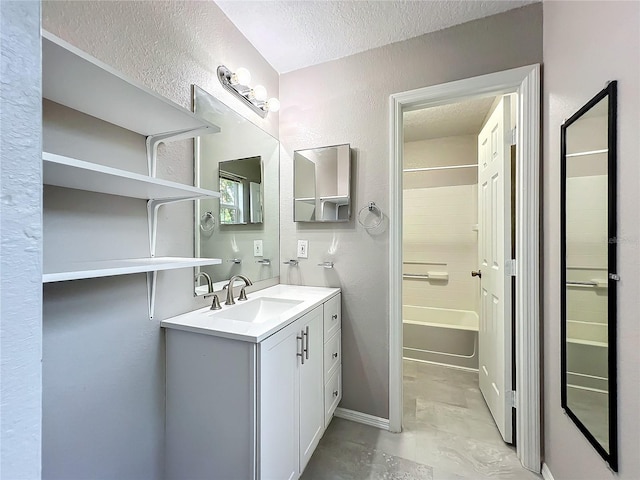 bathroom with vanity, shower / washtub combination, a textured ceiling, and tile patterned flooring