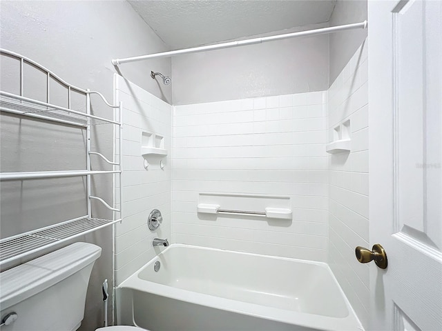 bathroom with tiled shower / bath, toilet, and a textured ceiling