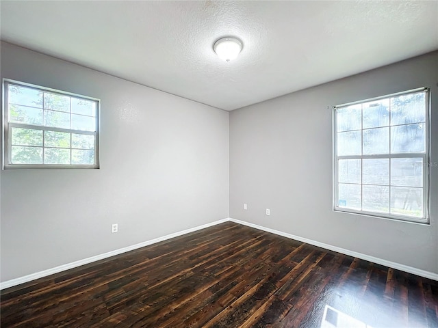 spare room featuring hardwood / wood-style floors and plenty of natural light