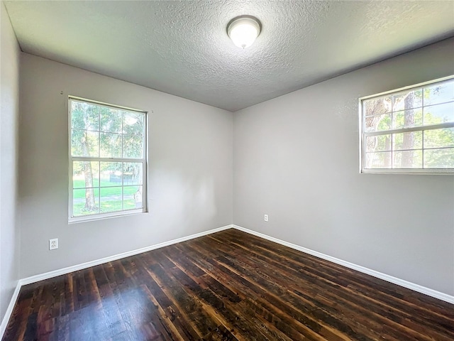 unfurnished room with a textured ceiling, hardwood / wood-style flooring, and plenty of natural light