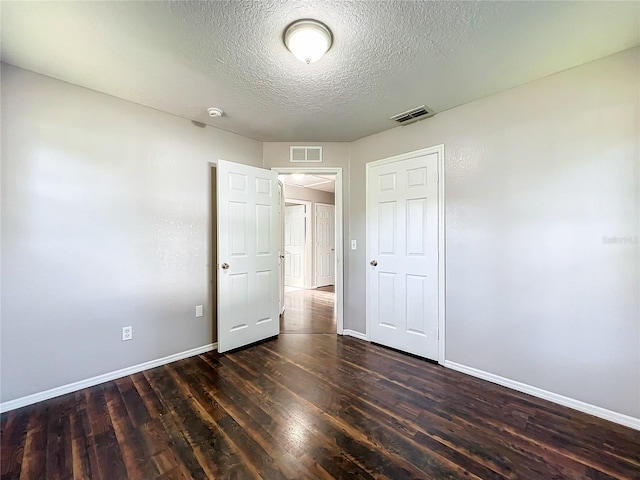 unfurnished bedroom featuring a closet, hardwood / wood-style floors, and a textured ceiling