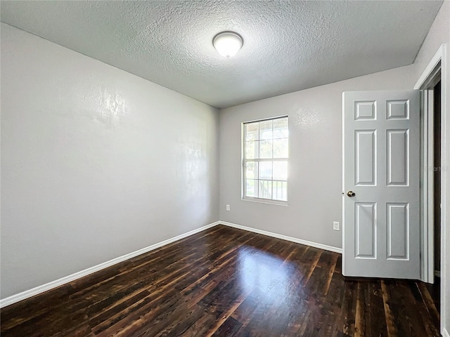 spare room featuring a textured ceiling and hardwood / wood-style floors