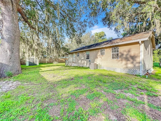 back of house featuring cooling unit and a lawn