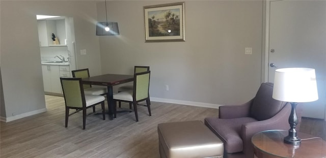 dining area with sink and wood-type flooring