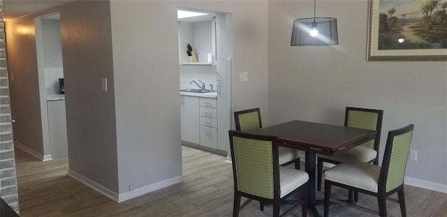 dining space with hardwood / wood-style floors and sink