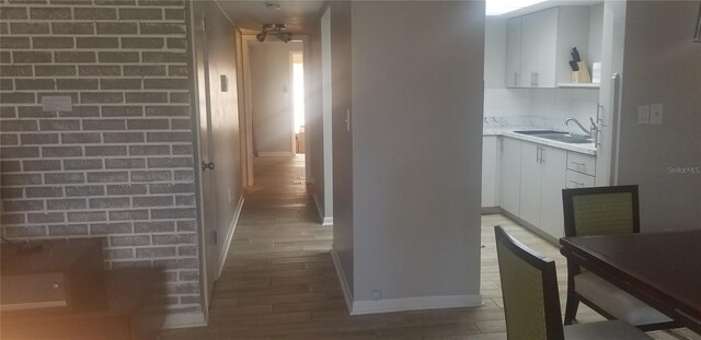 hallway featuring sink and hardwood / wood-style flooring