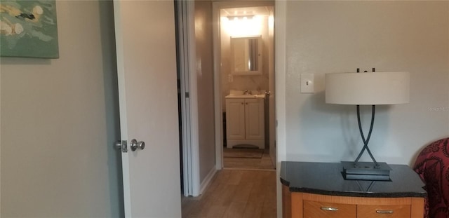 corridor with sink and hardwood / wood-style flooring