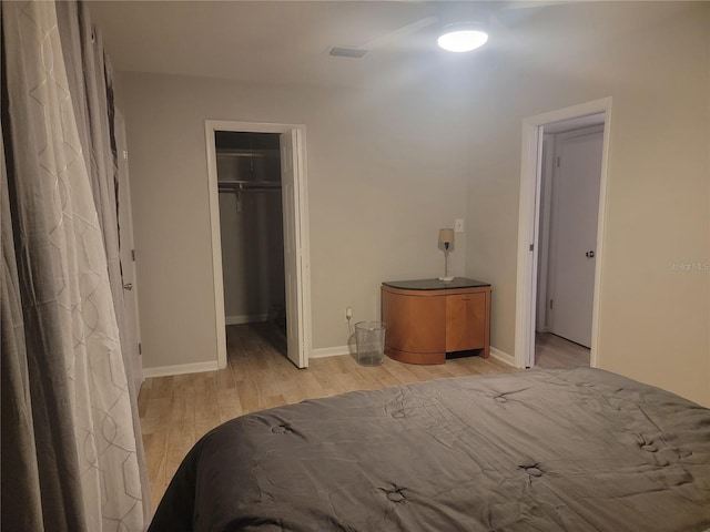 unfurnished bedroom with light hardwood / wood-style flooring, a closet, and a spacious closet