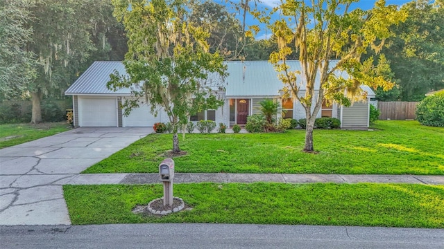 ranch-style home featuring a front lawn and a garage