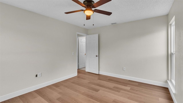 unfurnished room with ceiling fan, a textured ceiling, and light hardwood / wood-style floors