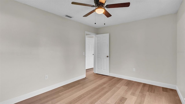 empty room with ceiling fan and light hardwood / wood-style floors