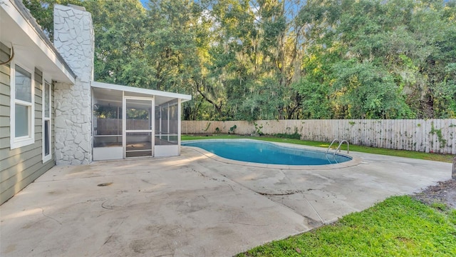 view of pool with a sunroom and a patio area