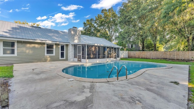 view of swimming pool featuring a sunroom and a patio area