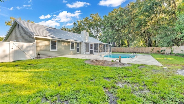 back of property with a fenced in pool, a patio area, and a yard