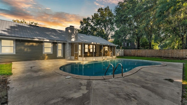 pool at dusk featuring a patio area