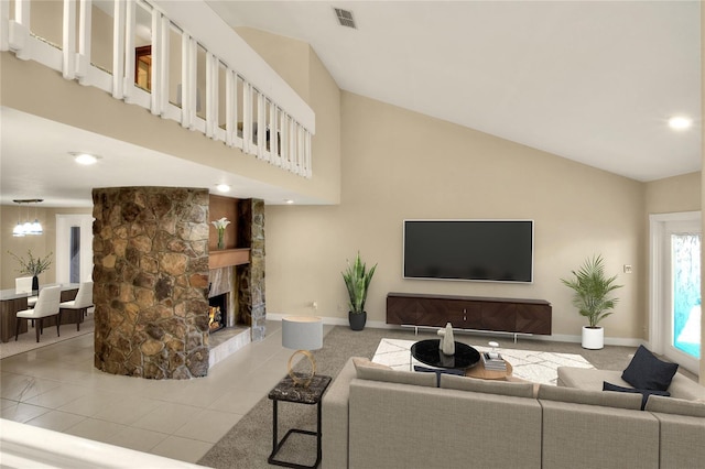 living area featuring light tile patterned floors, high vaulted ceiling, a stone fireplace, visible vents, and baseboards