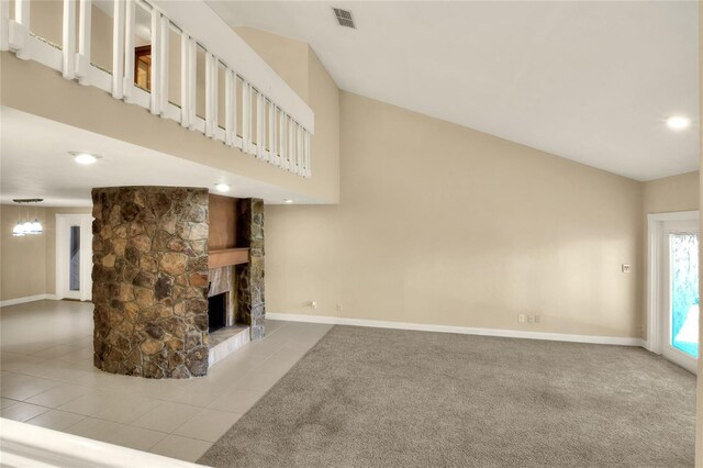 unfurnished living room with carpet flooring, visible vents, a stone fireplace, and baseboards