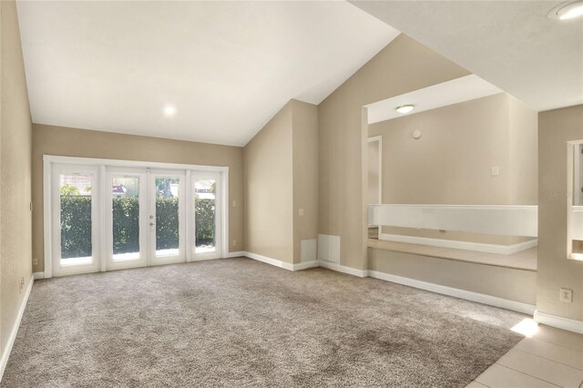 interior space featuring french doors, vaulted ceiling, and light colored carpet