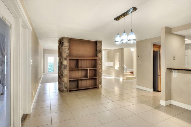 unfurnished living room with light tile patterned floors and a chandelier