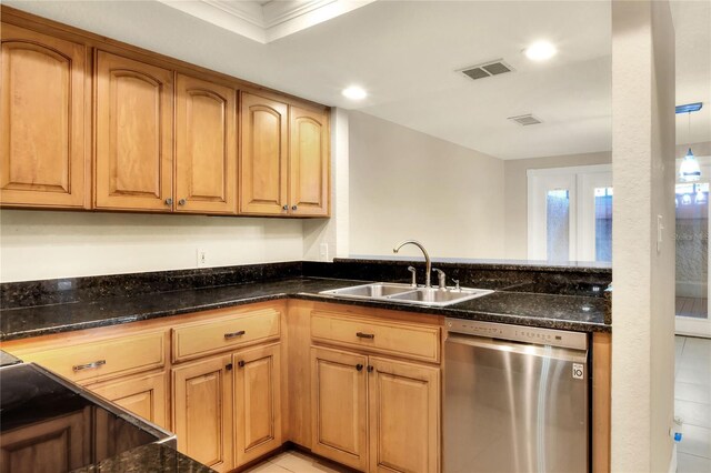 kitchen featuring dark stone countertops, sink, light tile patterned flooring, ornamental molding, and stainless steel dishwasher