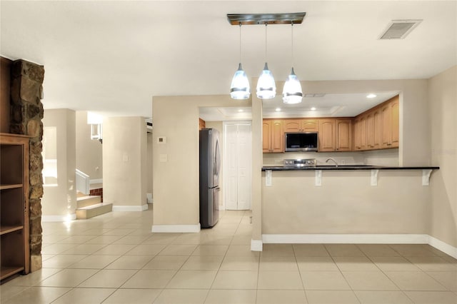 kitchen featuring kitchen peninsula, pendant lighting, light tile patterned floors, stainless steel appliances, and sink