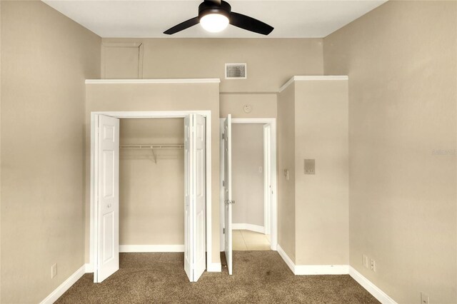 unfurnished bedroom with ceiling fan, carpet floors, and a closet