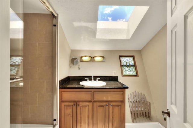 full bathroom with a tile shower and vanity