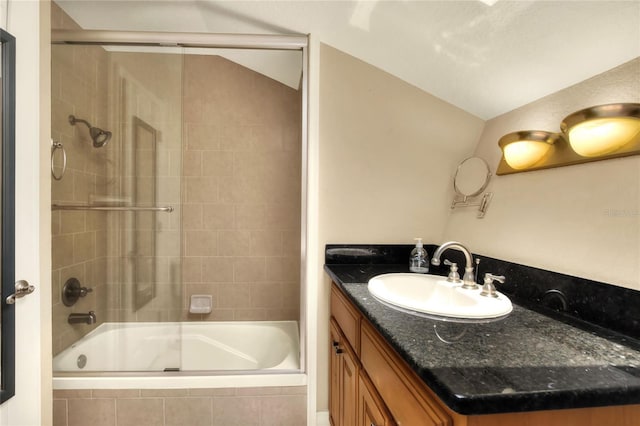 full bathroom featuring tiled shower / bath, vaulted ceiling, and vanity