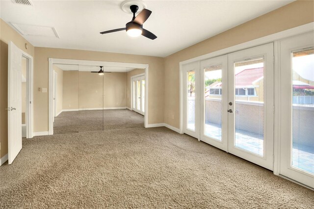 carpeted spare room with ceiling fan and french doors