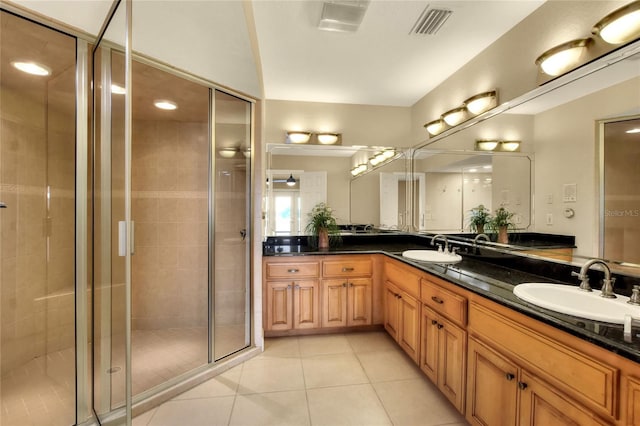 bathroom with a stall shower, tile patterned flooring, a sink, and visible vents