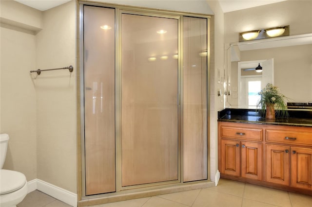 full bath with tile patterned flooring, toilet, vanity, baseboards, and a stall shower