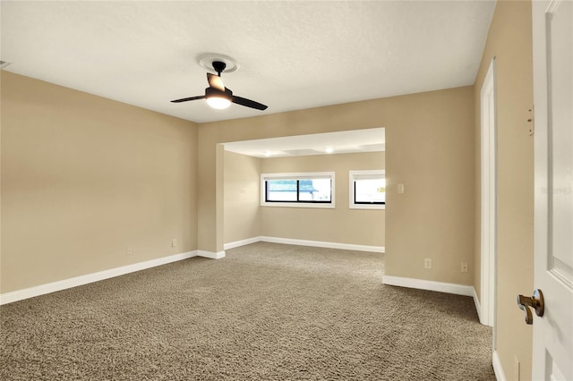 carpeted empty room featuring ceiling fan, baseboards, and a textured ceiling