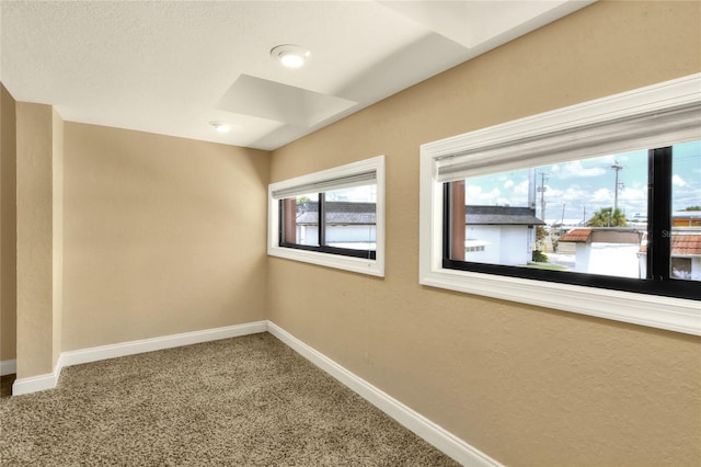 empty room featuring carpet floors and baseboards